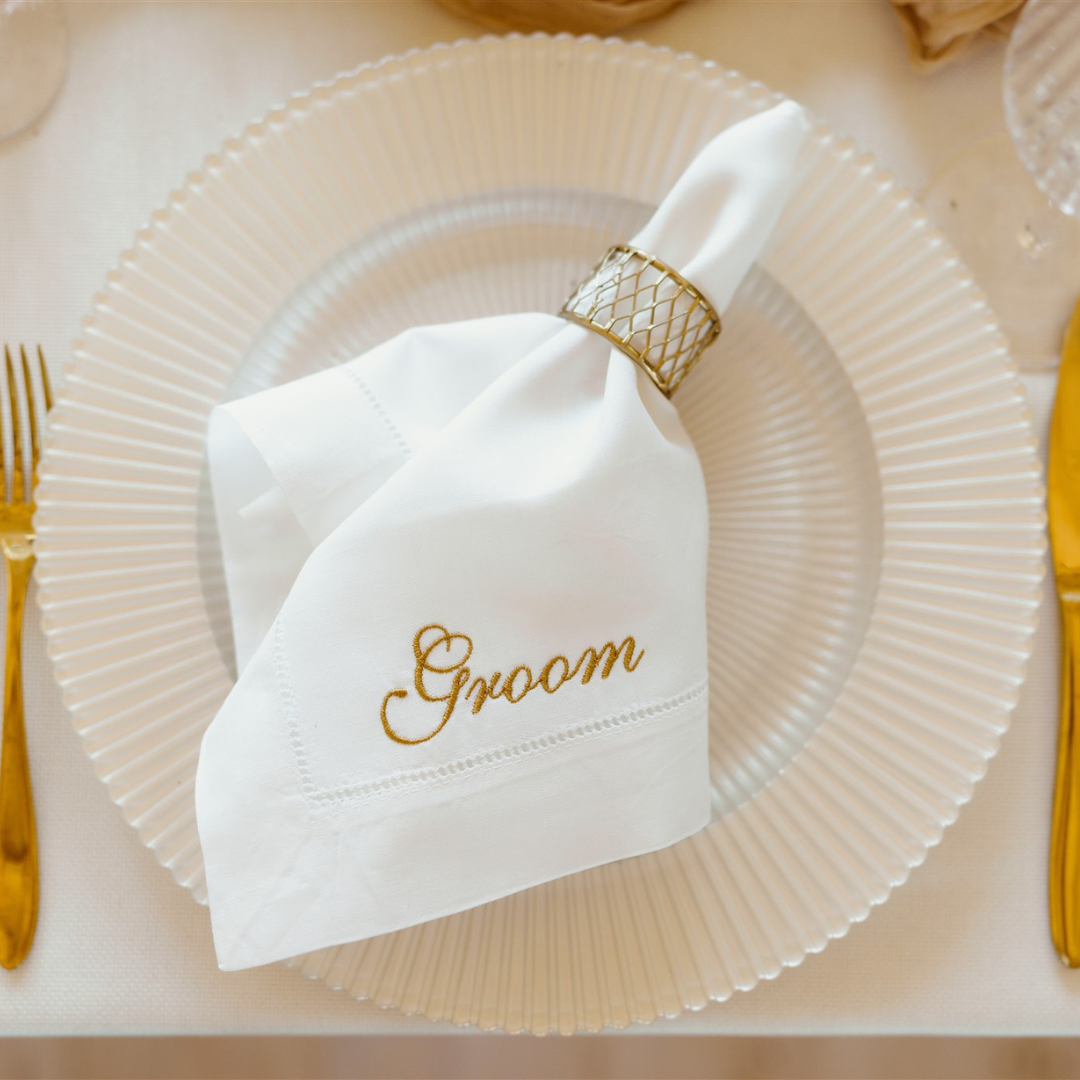 An embroidered napkin for the Groom, presented on a small plate