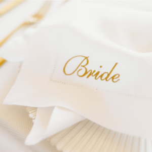 Close up shot of a white and gold embroidered wedding napkin for the bride