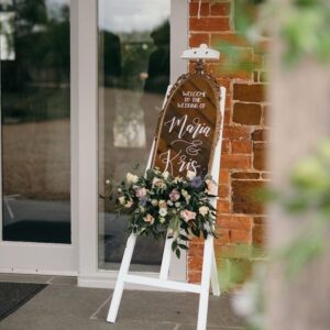 Custom wedding mirror sign displayed with flowers on an easel
