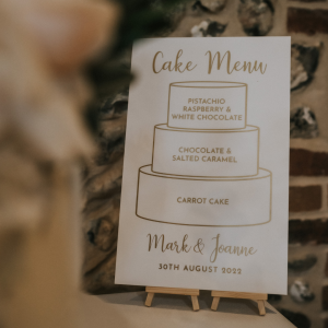 White and gold acrylic wedding cake menu sign