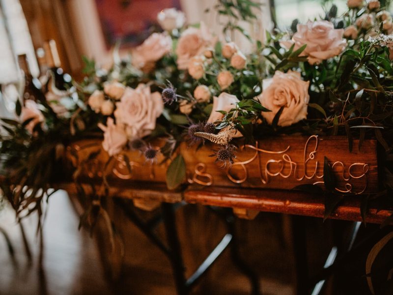Wooden wedding signage with a floral display on top